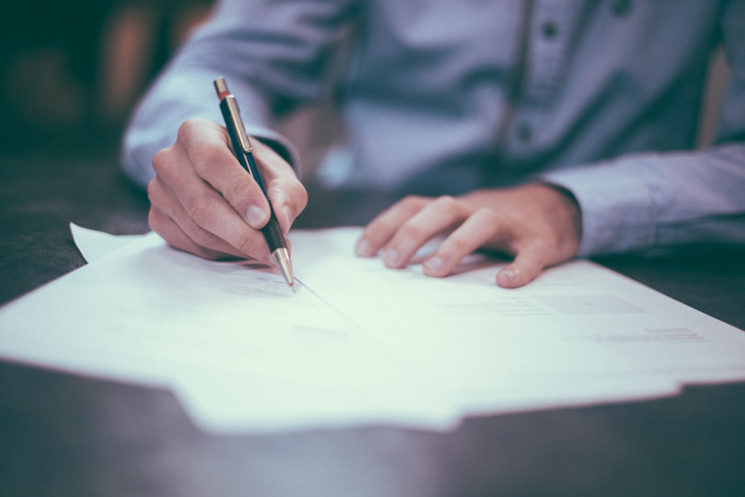 Person signing a claim form with a pen