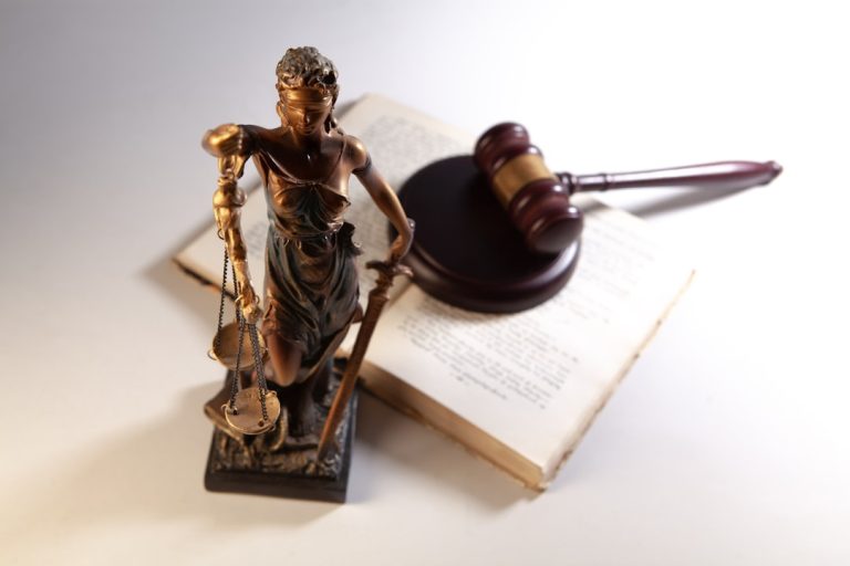 Statue of justice with gavel and law books